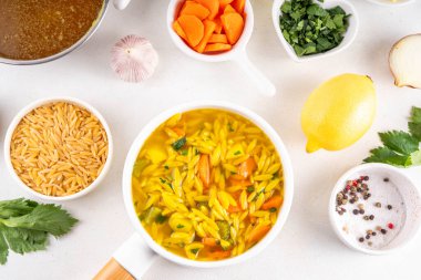 Lezzetli İtalyan Penisilin Çorbası, Sonbahar Kış Bağışıklık Desteği Tavuk Sebzeli Orzo Çorbası. Geleneksel Avrupa yemekleri ve beyaz masada yemek pişirmek için malzemeler