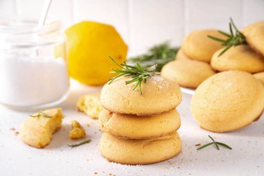 Baharatlı biberiye ve limonlu kurabiye. Tuzlu peynirli kurabiye aperatifleri ve beyaz mutfak masasında yemek pişirmek için gerekli malzemeler.