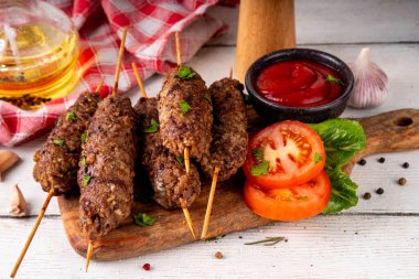 Çubuklu şiş kebap, kıymalı kıymadan yapılır. Lula kebap, geleneksel Kafkas yemeği, ketçap, baharat ve sebze salatası, barbekü ızgara pişirme arka planı fotokopi alanı yukarıda. 