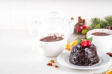 Geleneksel İngiliz Noel pudingli kek. Basit bir Noel pudingi fikri, mikrodalgayla yapılmış çay fincanı, şekerli Noel pudingi ve kızılcık şenliği dekoru.