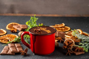 Geleneksel noel sıcak çikolata bardağı kurutulmuş portakal, tarçın, anason, baharat ve Noel ağacı dalları boşluğu doldurur.