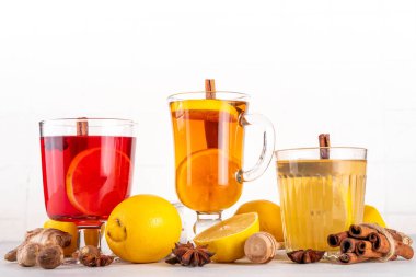 Farklı çay fincanlarında üç farklı sıcak hurma içeceği - sıcak sonbahar kış çayı kokteylleri viski, rom ve mezcal alkol içecekleri, baharatlar, limon ve bal