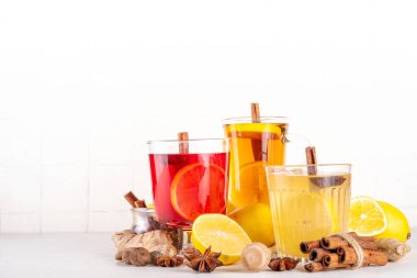 Farklı çay fincanlarında üç farklı sıcak hurma içeceği - sıcak sonbahar kış çayı kokteylleri viski, rom ve mezcal alkol içecekleri, baharatlar, limon ve bal