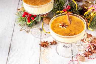 Geleneksel Noel Eggnog Martini ya da Brandy Alexander kokteyli tarçın ve hindistan cevizi, altın Noel süslemeleri ve bokeh efektiyle, uzay kopyalama