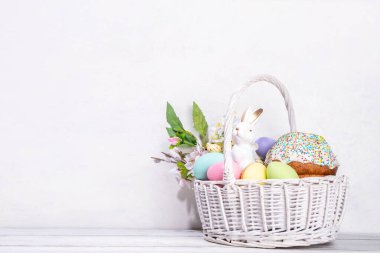 Paskalya pastalı geleneksel Paskalya sepeti rengarenk pastel yumurtalar, tavşan tavşanlar ve bahar çiçekleri. Paskalya kutlaması için hazırlık, tebrik kartı, davetiye, Paskalya indirimi