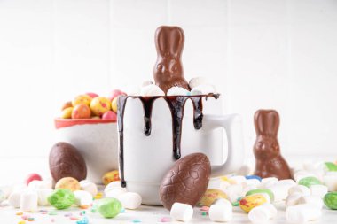 Çikolatalı ve tavşanlı Paskalya tatlı sıcak çikolata kupası, Paskalya sembollü ev yapımı kakao tarifi çikolatalar ve marşmelov, beyaz mutfak arka planı kopyalama alanı.