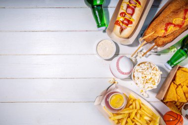Geleneksel spor stadyumu yemekleri ve bira arka planı, çeşitli beyzbol, basketbol, futbol fanatikleri ve stadyum atıştırmalıkları, cips, sos, bira şişeli sosisliler ve fan aksesuarları. 