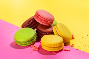 Parlak renkli (sarı, pembe, yeşil, kahverengi) çeşitli aromalı kurabiyeler yüksek renkli pembe arka planda tatlı kurabiyeler. Bir yığın küçük Fransız Makaronlu Kek, Boşluk Dizini Kopyala 