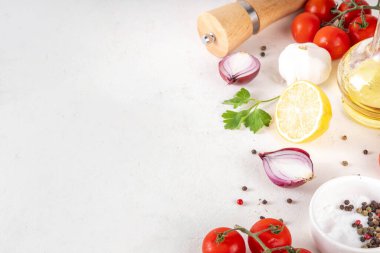 Baharatlar, karabiber, sarımsak, soğan, yeşillik ve domates, beyaz yemek masasında zeytin yağı. Beyaz taş arkaplanda yemek pişirmek için gerekli malzemeler..