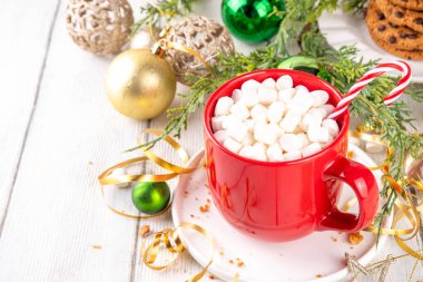 Sıcak çikolatalı şenlikli kırmızı kupa ya da marşmelovlu latte, Noel sabahı için, Noel arkaplanda sıcak sıcak sıcak bir tatil içeceği.