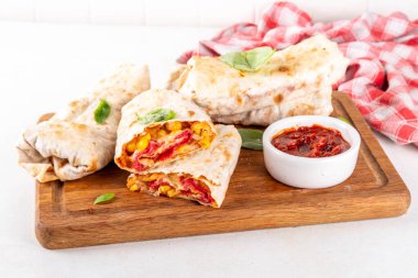 Ev yapımı fırında pizza, pizza stili quesadilla dürümleri pepperoni ya da salam, domates, peynir ve mısır, mutfak masasında sıcak domates sosu, fotokopi alanı.