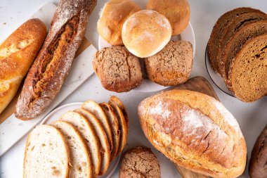 Set of various Prebiotic Bread with live bacteria, prebiotics, fiber for gut health. Healthy alternative to regular bread, different rye, white, grain bread and buns on white table background