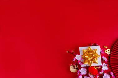 Mandarin portakalları, çiçek açan ağaç dalları, dekoratif yelpazeler, kutlama amaçlı karşılama zarfları ve sikkeleri, geleneksel Çin Yeni Yıl süsleri olan parlak altın ve kırmızı Çin Yeni Yılı geçmişi.