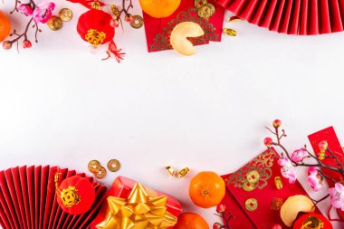 Mandarin portakalları, çiçek açan ağaç dalları, dekoratif yelpazeler, kutlama amaçlı karşılama zarfları ve sikkeleri, geleneksel Çin Yeni Yıl süsleri olan parlak altın ve kırmızı Çin Yeni Yılı geçmişi.