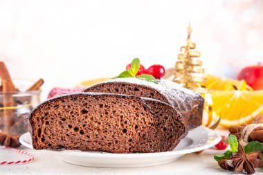 Ev yapımı zencefilli kek. Taze pişmiş Noel zencefilli çikolatalı pasta üzerine şeker tozu, beyaz şenlikli arka plan