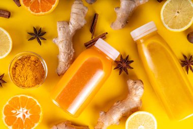 Zencefilli zerdeçal bağışıklık aşısı, portakal, limon, zerdeçal, zencefil, tarçın, baharat, alternatif ilaç gribi ve soğuk algınlığı şurubuyla karıştırılmış küçük şişelerde yapılan lezzetli vitamin narenli meyve içeceği.