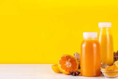 Zencefilli zerdeçal bağışıklık aşısı, portakal, limon, zerdeçal, zencefil, tarçın, baharat, alternatif ilaç gribi ve soğuk algınlığı şurubuyla karıştırılmış küçük şişelerde yapılan lezzetli vitamin narenli meyve içeceği.