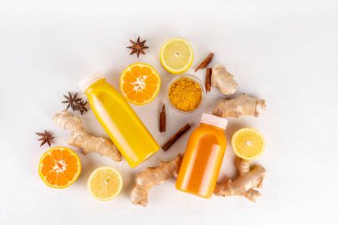 Zencefilli zerdeçal bağışıklık aşısı, portakal, limon, zerdeçal, zencefil, tarçın, baharat, alternatif ilaç gribi ve soğuk algınlığı şurubuyla karıştırılmış küçük şişelerde yapılan lezzetli vitamin narenli meyve içeceği.