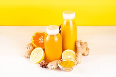 Zencefilli zerdeçal bağışıklık aşısı, portakal, limon, zerdeçal, zencefil, tarçın, baharat, alternatif ilaç gribi ve soğuk algınlığı şurubuyla karıştırılmış küçük şişelerde yapılan lezzetli vitamin narenli meyve içeceği.