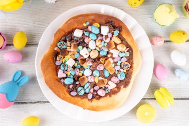 Tatlı Paskalya tatlı pizzası, çikolata soslu, marşmelov ve çikolatalı yumurta, Paskalya bayramı çocukları için atıştırmalık, şenlikli süslemeler, renkli yumurtalar ve tavşan tavşanlı.