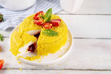 Tepetaklak Pasta yok, klasik Cheesecake New York 'un viral modası altın kurabiye parçacıkları, beyaz krem peynir ve böğürtlen reçeli katmanları, taze çilek ve ahşap masa üzerinde nane