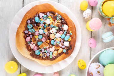 Tatlı Paskalya tatlı pizzası, çikolata soslu, marşmelov ve çikolatalı yumurta, Paskalya bayramı çocukları için atıştırmalık, şenlikli süslemeler, renkli yumurtalar ve tavşan tavşanlı.
