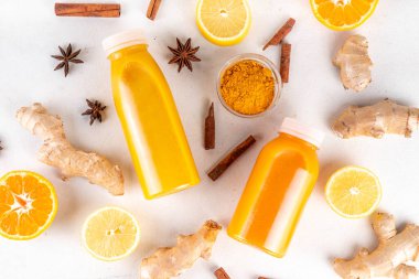 Zencefilli zerdeçal bağışıklık aşısı, portakal, limon, zerdeçal, zencefil, tarçın, baharat, alternatif ilaç gribi ve soğuk algınlığı şurubuyla karıştırılmış küçük şişelerde yapılan lezzetli vitamin narenli meyve içeceği.