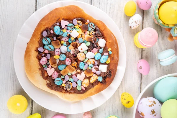 Tatlı Paskalya tatlı pizzası, çikolata soslu, marşmelov ve çikolatalı yumurta, Paskalya bayramı çocukları için atıştırmalık, şenlikli süslemeler, renkli yumurtalar ve tavşan tavşanlı.