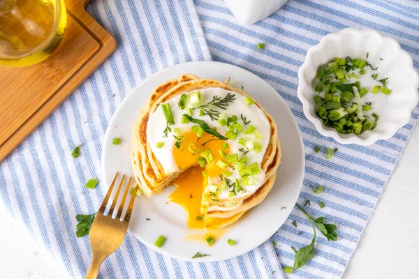 Lezzetli kahvaltı krepleri, taze soğan ve kızarmış yumurta. Lezzetli ya da tatlı olmayan krepleri beyaz mutfak masasında maydanozlu ve güneşli yumurtalarla fotokopi masasının üzerinde.