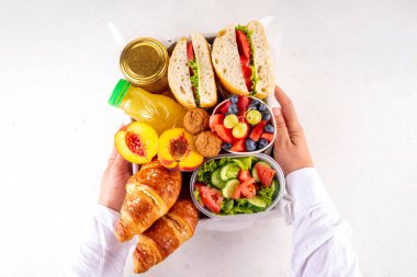 Hazırlık ya da hazır brunch kutusu sandviç, salata, kruvasan, tatlı olarak kurabiye ve meyve suyu, meyve suyu ya da meyve suyu. Kısa bir öğle yemeği molası, zaman tasarrufu, sağlıklı yemek.