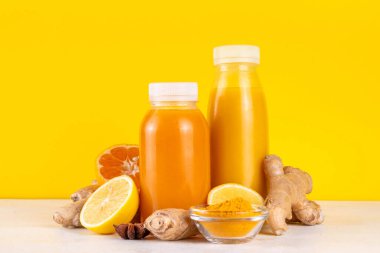 Zencefilli zerdeçal bağışıklık aşısı, portakal, limon, zerdeçal, zencefil, tarçın, baharat, alternatif ilaç gribi ve soğuk algınlığı şurubuyla karıştırılmış küçük şişelerde yapılan lezzetli vitamin narenli meyve içeceği.