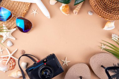 Yaz tatili ve hasır şapkalı, çantalı, terlikli, palmiye yapraklı, güneş gözlüklü, kameralı, deniz kabuklu ve okyanus yıldızlı tatil geçmişi. Plaj ve tropikal yaz tatili arka planı, üst görünüm kopyalama alanı
