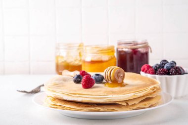 Geleneksel Maslenitsa yemekleri, Doğu Avrupa Slav ince krepleri, çeşitli tatlı soslar, malzemeler ve dolgular - bal, dut, reçel