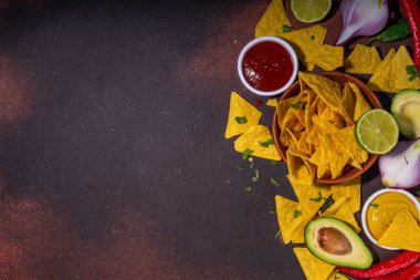 Traditional Mexican street food, fast food background, corn Taco, nachos with meat, vegetables, avocado, beans, corn, salsa. Served with various sauces. Mexican holiday flatlay