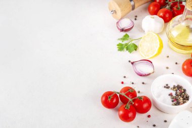 Baharatlar, karabiber, sarımsak, soğan, yeşillik ve domates, beyaz yemek masasında zeytin yağı. Beyaz taş arkaplanda yemek pişirmek için gerekli malzemeler..