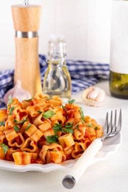 Kalp şeklinde domates soslu makarna. Klasik İtalyan salamura soslu makarna ya da taze otlu bolonez makarna. Sevgililer günü ya da randevu gecesi için basit ve lezzetli bir tarif. Beyaz masa fotokopisinde.
