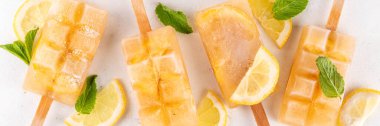 Buzlu çay veya limonata, tatlı limon ve naneli kokteyl lolipopları soğuk içecek, limon dilimleri ve nane yaprakları fotokopi alanı