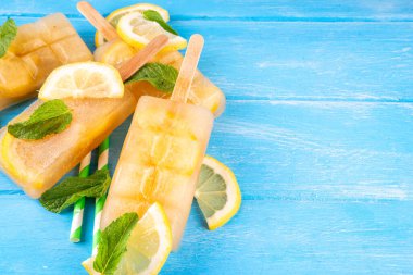 Buzlu çay veya limonata, tatlı limon ve naneli kokteyl lolipopları soğuk içecek, limon dilimleri ve nane yaprakları fotokopi alanı