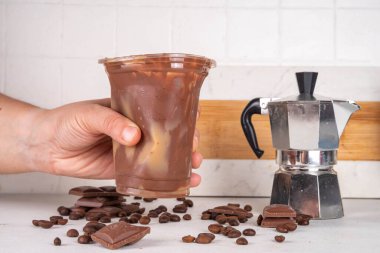 Viral Çikolatalı Latte içeceği. Buzlu latte ve mocachino ile doldurulmuş çikolatalı plastik bardak.