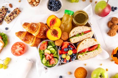 Hazırlık ya da hazır brunch kutusu sandviç, salata, kruvasan, tatlı olarak kurabiye ve meyve suyu, meyve suyu ya da meyve suyu. Kısa bir öğle yemeği molası, zaman tasarrufu, sağlıklı yemek.