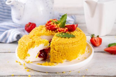 Tepetaklak Pasta yok, klasik Cheesecake New York 'un viral modası altın kurabiye parçacıkları, beyaz krem peynir ve böğürtlen reçeli katmanları, taze çilek ve ahşap masa üzerinde nane