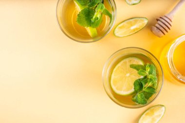 Sıcak mojito çayı kokteyli, rom, nane ve limon dilimleri, viral soğuk kış mevsimi ısıtma motty - mojito versiyonu, bal ve masa arkasında malzemelerle birlikte.