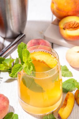 Şeftalili mojito ya da limonatalı soğuk meyve suyu, yaz buzlu meyve suyu nane ve limonlu moktail, beyaz ahşap masa.