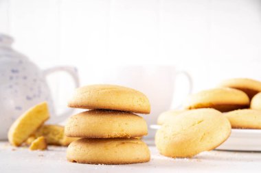 Ev yapımı kurabiyeler, geleneksel İngiliz çay partisi tereyağlı kurabiyeler, beyaz mutfak masasında tatlı kurabiyeler.