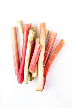 Çiğ organik ravent, beyaz arka planda bir demet ev yapımı pembe ve yeşil ravent, yemek, tatlı veya reçel için hazırdır. Yaz hasadı, yemek malzemeleri.