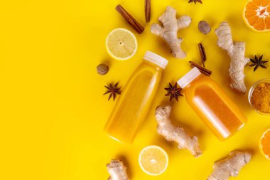 Zencefilli zerdeçal bağışıklık aşısı, portakal, limon, zerdeçal, zencefil, tarçın, baharat, alternatif ilaç gribi ve soğuk algınlığı şurubuyla karıştırılmış küçük şişelerde yapılan lezzetli vitamin narenli meyve içeceği.