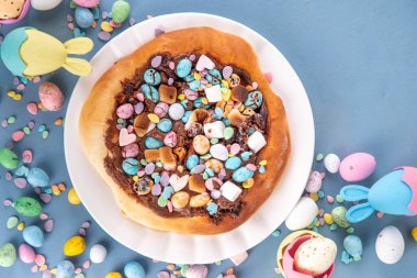 Tatlı Paskalya tatlı pizzası, çikolata soslu, marşmelov ve çikolatalı yumurta, Paskalya bayramı çocukları için atıştırmalık, şenlikli süslemeler, renkli yumurtalar ve tavşan tavşanlı.