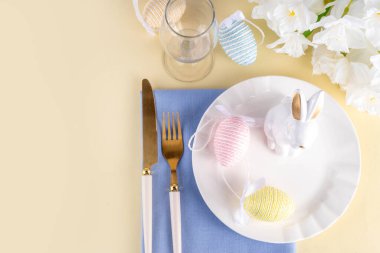 Tabak, çatal bıçak seti tavşanı, paskalya yumurtası, peçete ve bahar çiçekleri pastel renkli arka plan, fotokopi alanı, akşam yemeği davetinde Paskalya kahvaltısı, kafe menüsü...