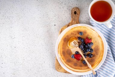 Ev yapımı küçük Fransız krepleri, böğürtlen ve ballı tereyağlı kekler. Bir yığın taze pişmiş geleneksel Maslenitsa yemeği, Doğu Avrupa Slav ince krep kahvaltısı ya da öğle yemeği