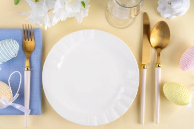 Tabak, çatal bıçak seti tavşanı, paskalya yumurtası, peçete ve bahar çiçekleri pastel renkli arka plan, fotokopi alanı, akşam yemeği davetinde Paskalya kahvaltısı, kafe menüsü...